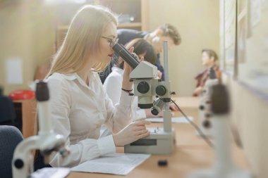 iki kız ve bir erkek mikroskoplar ile çalışmak