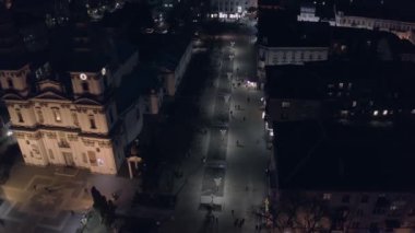 Şehrin gece görüşü, manzarası, binalar, insanlar ve arabalar.