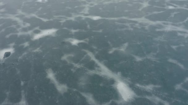 Flug über ein gefrorenes Eis auf einem Stausee, Draufsicht. Wintersee. Eis und Geröll. — Stockvideo