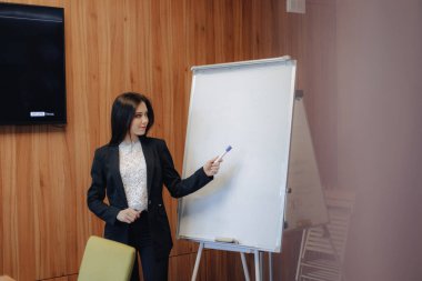 modern bir ofiste flipchart veya seyirci tek başına çalışan iş tarzı giysiler genç duygusal çekici kız