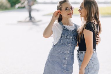 Parkta ya da sokakta yürüyen iki güzel kız. Güneşli bir yaz günü, neşe ve dostluklar.