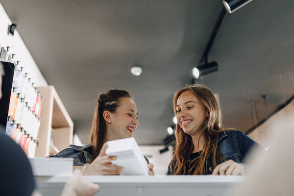 молодые привлекательные девушки в магазине электроники покупают новые телефоны. концепция покупки гаджетов
.