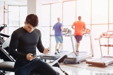 Genç antrenör spor salonunda notlar alıyor. Spor için özel antrenör. spor ve spor.