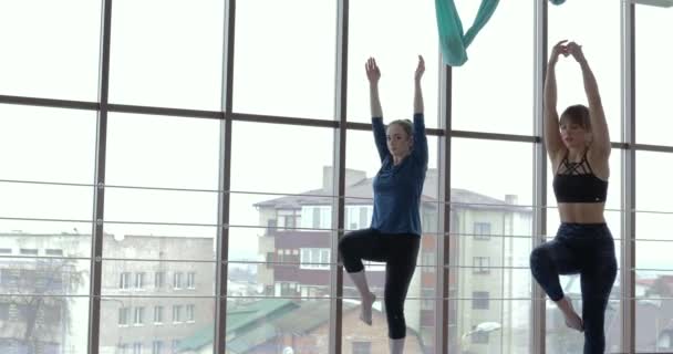 Niñas practican yoga en una habitación grande y luminosa. entrenador y estudiante. concepto de entrenamiento deportivo . — Vídeo de stock