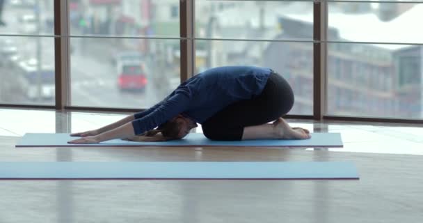 Niñas practican yoga en una habitación grande y luminosa. entrenador y estudiante. concepto de entrenamiento deportivo . — Vídeos de Stock