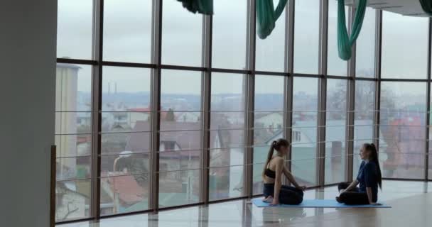 Flickor utövar yoga i ett stort, ljust rum. coach och elev. idrottsträning. — Stockvideo