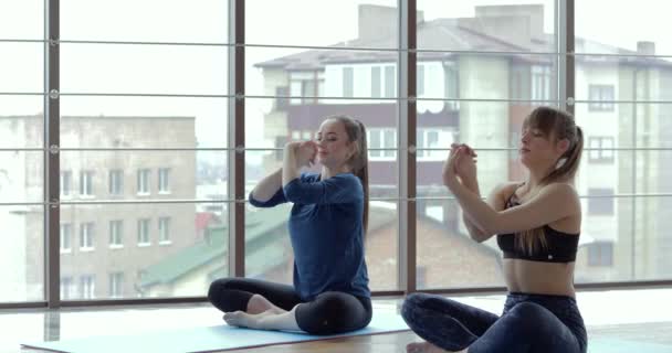 Le ragazze praticano yoga in una grande stanza luminosa. allenatore e studente. concetto di allenamento sportivo . — Video Stock