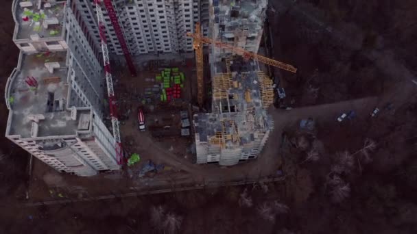 Günbatımında ev inşaatının üstündeki uçuş manzarası. Turna ve inşaat işlemleri. — Stok video