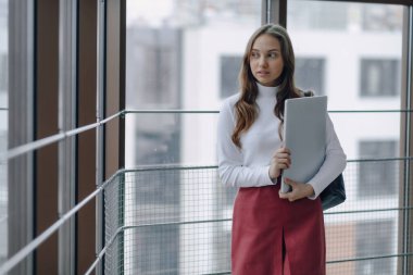 Çekici bir kız, havaalanı terminalinde ya da ofiste dizüstü bilgisayarla parlak bir koridorda yürüyor. seyahat atmosferi ya da alternatif çalışma ortamı. Serbest çalışan öğrenci, teknolojiyle iş toplantısına gidiyor..