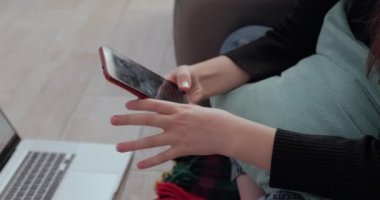 Bilgisayarın arkasında elinde telefonla sıcak çay içen yakın plan bir kız. Evde kalmaktan yorgun düştüm. Evden izolasyon ve iş.