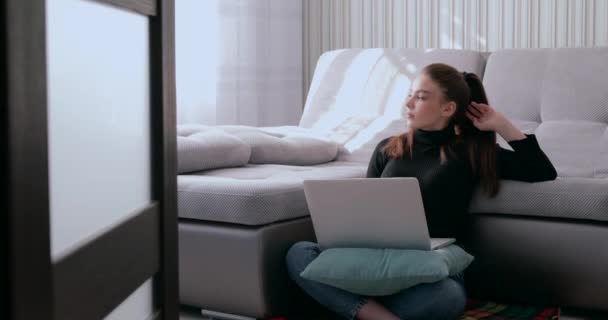 Chica bebiendo té caliente y trabajando en el ordenador portátil. fatiga por quedarse en casa. aislamiento y trabajo desde el hogar . — Vídeo de stock