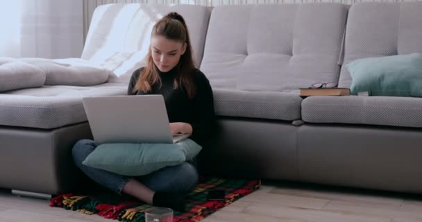 Flicka som dricker varmt te och arbetar på laptop. trötthet efter att ha stannat hemma. isolering och arbete hemifrån. — Stockvideo