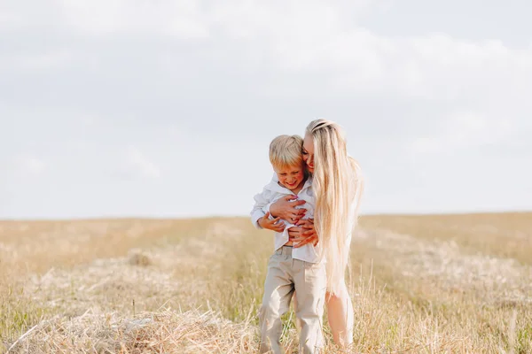 Menino Loiro Brincando Com Mãe Com Cabelos Brancos Com Feno — Fotografia de Stock