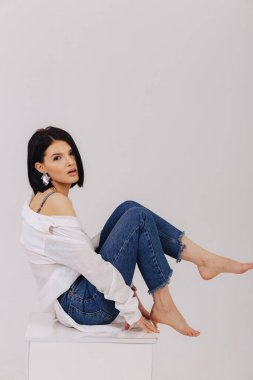 Stüdyoda parlak arka planda poz veren iş elbiseli çekici bir genç kız. Şık kıyafetler ve entelektüellik kavramı. Basit arkaplan.