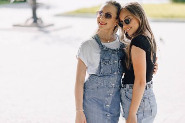 Parkta ya da sokakta yürüyen iki güzel kız. Güneşli bir yaz günü, neşe ve dostluklar.