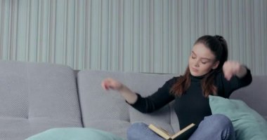 Kız kitap okumaktan ve kanepede yoğurmaktan yoruldu. Evde, rahatlama. Kişisel gelişim ve nasıl iktidarda kalınacağı.