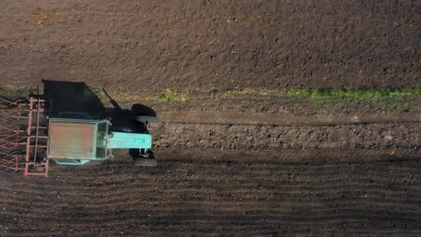 vue de dessus, vue aérienne. le tracteur cultive la terre. préparation aux cultures. l'agriculture dans le village et à la campagne .