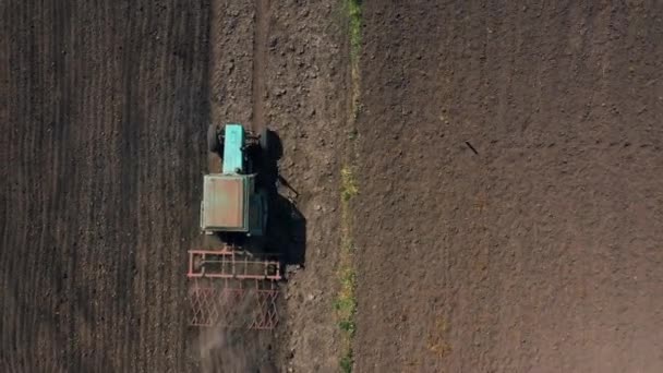 vue de dessus, vue aérienne. le tracteur cultive la terre. préparation aux cultures. l'agriculture dans le village et à la campagne .