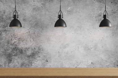 Gri beton arka planda, tavan lambalarında, ahşap yüzeyde üç siyah kolye ışığı.
