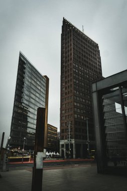 Berlin 'deki Potsdamer Platz' da gökdelenler. Arka planda dramatik gökyüzü olan gökdelenler. Berlin 'de seyahat ve turizm. Berlin 'in iş merkezleri.