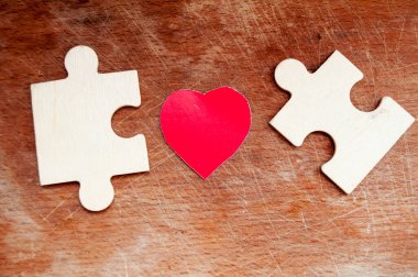 Tahta bulmacaların yanında kırmızı kağıt kalpler. Dünya Otizm Farkındalık Günü. 2 Nisan