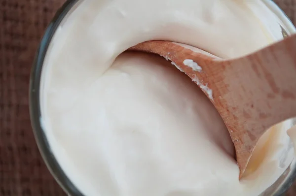 Çiftlik yapımı ekşi krema ve tahta kaşık. Eko ürünler. Süt ürünleri.