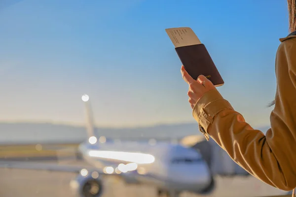 旅客妇女携带的护照和登机证随时待命 可在柜台登机门登机 飞机停靠在候机楼等候按预定时间送达 或需要延期提供额外维修服务 — 图库照片