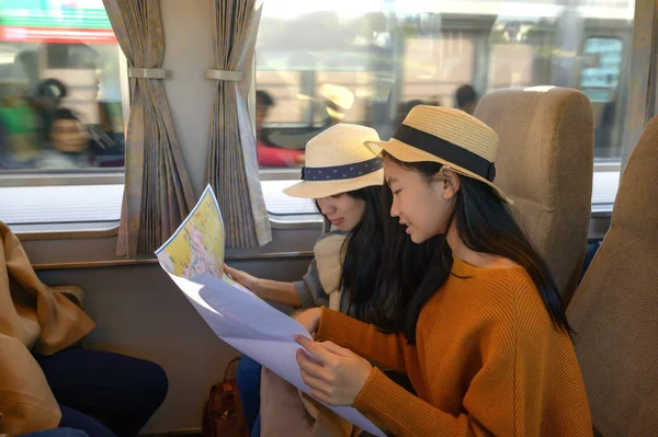 Women Traveller in transport on train looking in ordinary map for properly destination, travel on public transport by owns way selection