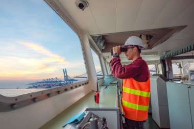 duty officer in charge handle of the ship navigating to the port destination, keep watching navigation on the bridge of the ship vessel under voyage sailing to the sea