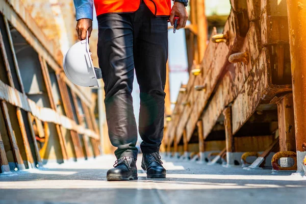 legs wearing safety shoe of engineering, worker, powerman walks on safety walkway, returns home after long day, waking after finished job, walks returns to site station