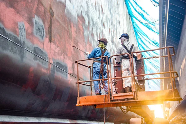 Steel basket carry by cherry picker crane for gang of worker power man, painting man or brush man working in high position, working at risk in dust under mesh sheet protectio