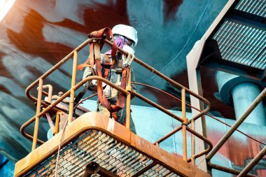worker power man painting man or brush man working in high position, working at risk of high level, safety working with safety hooks secured in bar against falling dow