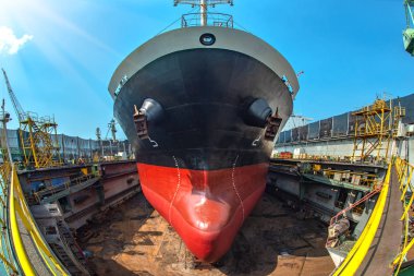 Gemi vinci tarafından yüklenen konteynır ünitesi, liman terminaline naklediliyor, liman işçisi çalışıyor, lojistik ve ulaşım hizmetleri dünya çapında küresel taşımacılık