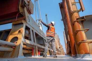 Gemi vinci tarafından yüklenen konteynır ünitesi, liman terminaline naklediliyor, liman işçisi çalışıyor, lojistik ve ulaşım hizmetleri dünya çapında küresel taşımacılık