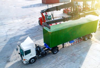 Aerial top view of container unit being loading onto the trailer by stacker, cargo ready to delivery to destination by transportation