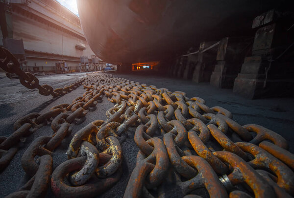 anchor chains bundle laying standing by at bottom layer of the ship in floating dry dock terminal, for recondition maintennant with sand blasting perform