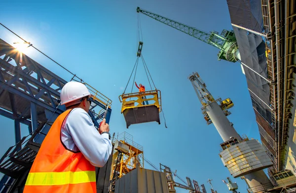 foreman, supervisor, worker, loading master in works at job site, control to the teamwork by walkie talkie radio for job done in the same direction, working at risk and high level of insuranc