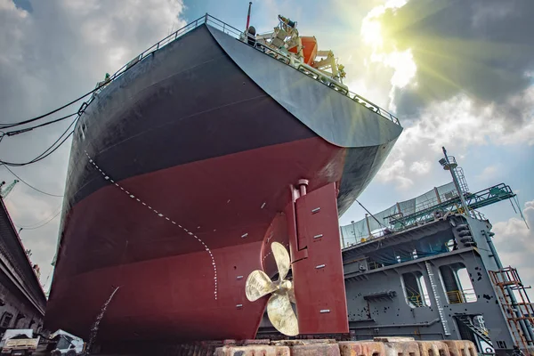 aft stern of the commercial ship in floating dry dock, painting , repairing, recondition of overhaul, ship sitting on supporter bottom of dry dock terminal