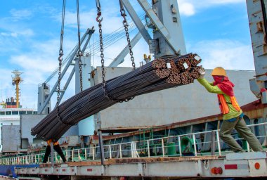 bundle of steel rod being loading discharging in port terminal, handle by gang of stevedore, shipment cargo in transition from land and sea transport services