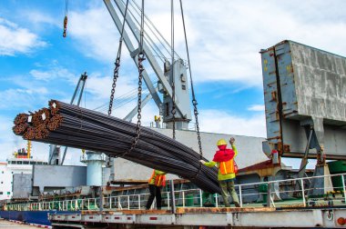 bundle of steel rod being loading discharging in port terminal, handle by gang of stevedore, shipment cargo in transition from land and sea transport services