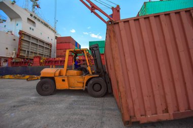 forklift handling unnit of container in port terminal, services from yard delivery to along side the ship for loading, being transhipment export and import
