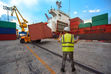 loading master, harbour controller in charge of container unit being lifting loading by the forklift handle from the storage yard, delivery to the ship in port terminal, the services being for logistics and transport shipment to worldwide 