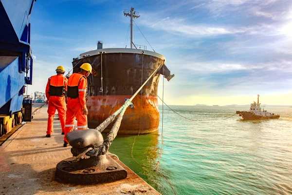 ship vessel is on leaving departure from the port terminal after completion of loading/discharging operation by gang of mooring attending at last party, tug boat standing by to safety assist towage