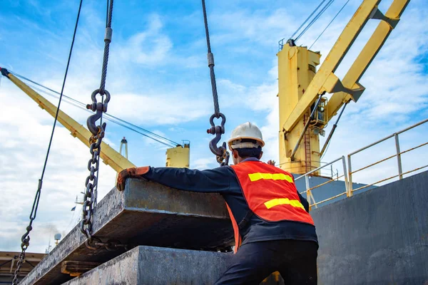 bundle of steel slab being loading discharging in port terminal, handle by gang of stevedore labor , shipment cargo in transition from land and sea transport services