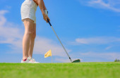 Golfspielerin konzentriert sich beim Schlag des Golfballs auf das Zielgrün für den Sieg bei der Punktzahl