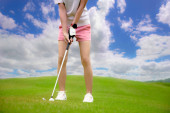 Golfball, der von einer Golfspielerin vom unebenen Fairway zum Zielgewinn auf dem Grün geschlagen oder gechipt wird, Zielkonzentrat für den Sieger die Punktzahl