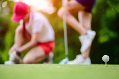 T-Off 'ta golfçünün vurmaya hazır olduğu ahşap bir golf topunu sokan kadın golfçüler, güneşli bir günde Goiong' dan sıcak topa top atmadan önce rahat hissediyorlar. 