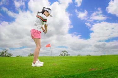 Kadın golfçü topa vurmaya konsantre ol. Hedef yeşile doğru git ve skor oranında kazan.