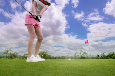 Çip golf topu olarak görev yapan kadın golfçü. Sert bir çim alanından hedefe, gündüz vakti yeşil alana kadar.