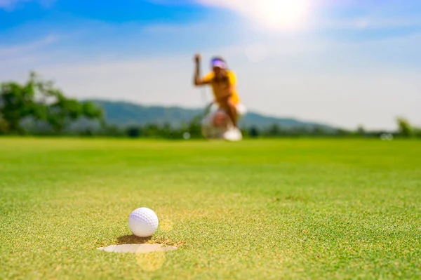 ゴルフボールは ゴルフホールには 女性のゴルフ選手 動揺や女性選手の災害を置くことで失われた手の届かないところに置くに従っていない — ストック写真